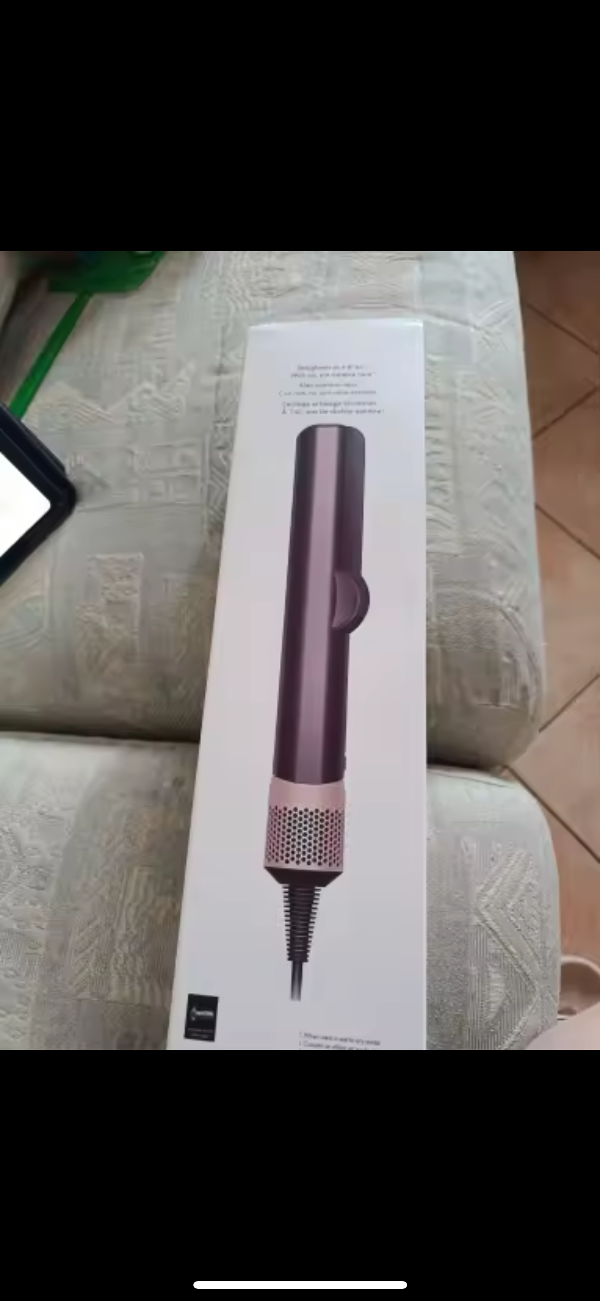 StyloAir 2-i-1 hårstyler i originalförpackning, placerad på soffa.