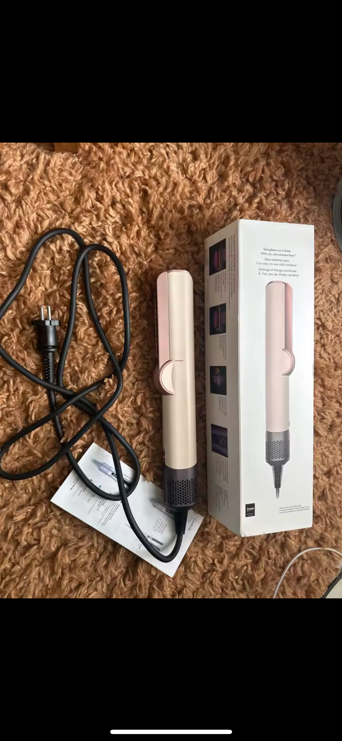 StyloAir 2-i-1 hårstyler i rosa och guld, placerad på matta bredvid förpackning och manual.