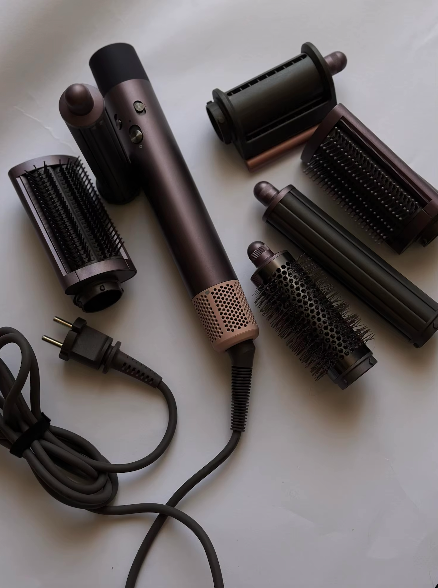 StyloAir multistyler i svart/roséguld med flera utbytbara tillbehör, inklusive rundborste, plattborstar och lockverktyg.