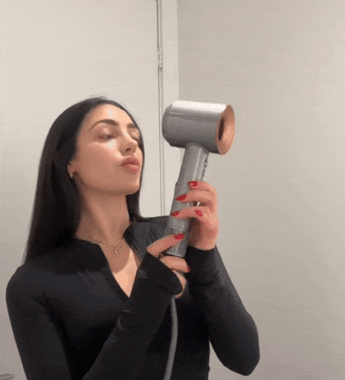 Video med Kvinna med långt mörkt hår använder StyloAir hårfön för styling.