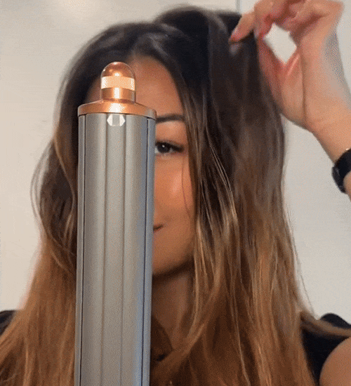 En kund som använder vår StyloAir Pro multistyler i blått med sex utbytbara tillbehör för alla stylingbehov.